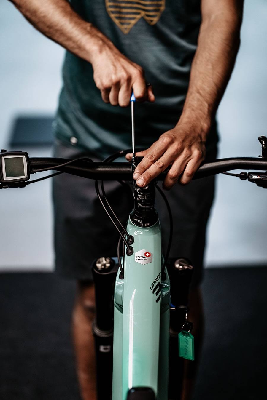 Ein Mitarbeiter von Schernthaner sports  richtet den Lenker eines Fahrrads mit einem Schraubendreher