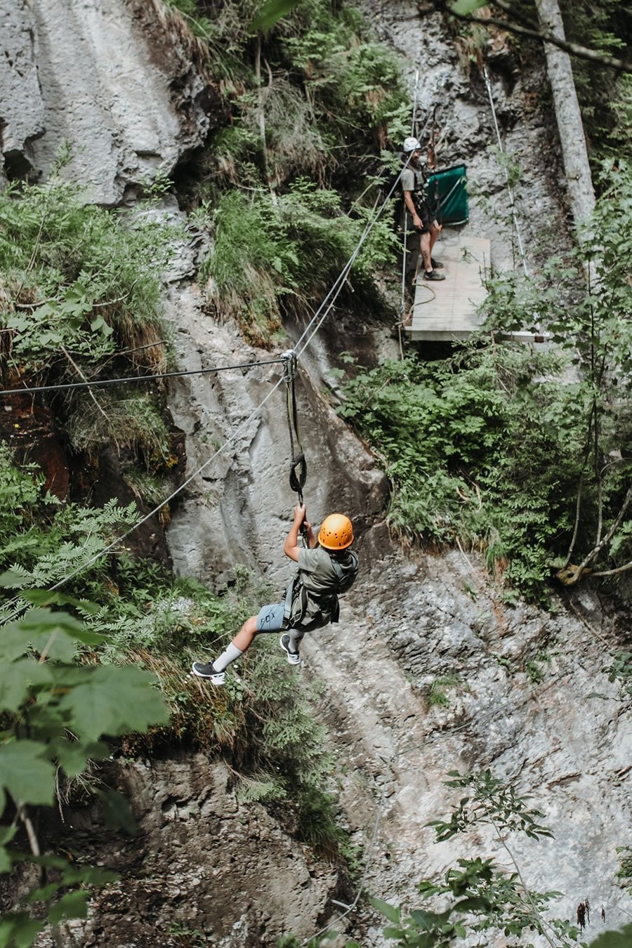 Auf dem Flying Fox über eine bewaldete, felsige Schlucht beim Klettersteig in Wagrain-Kleinarl