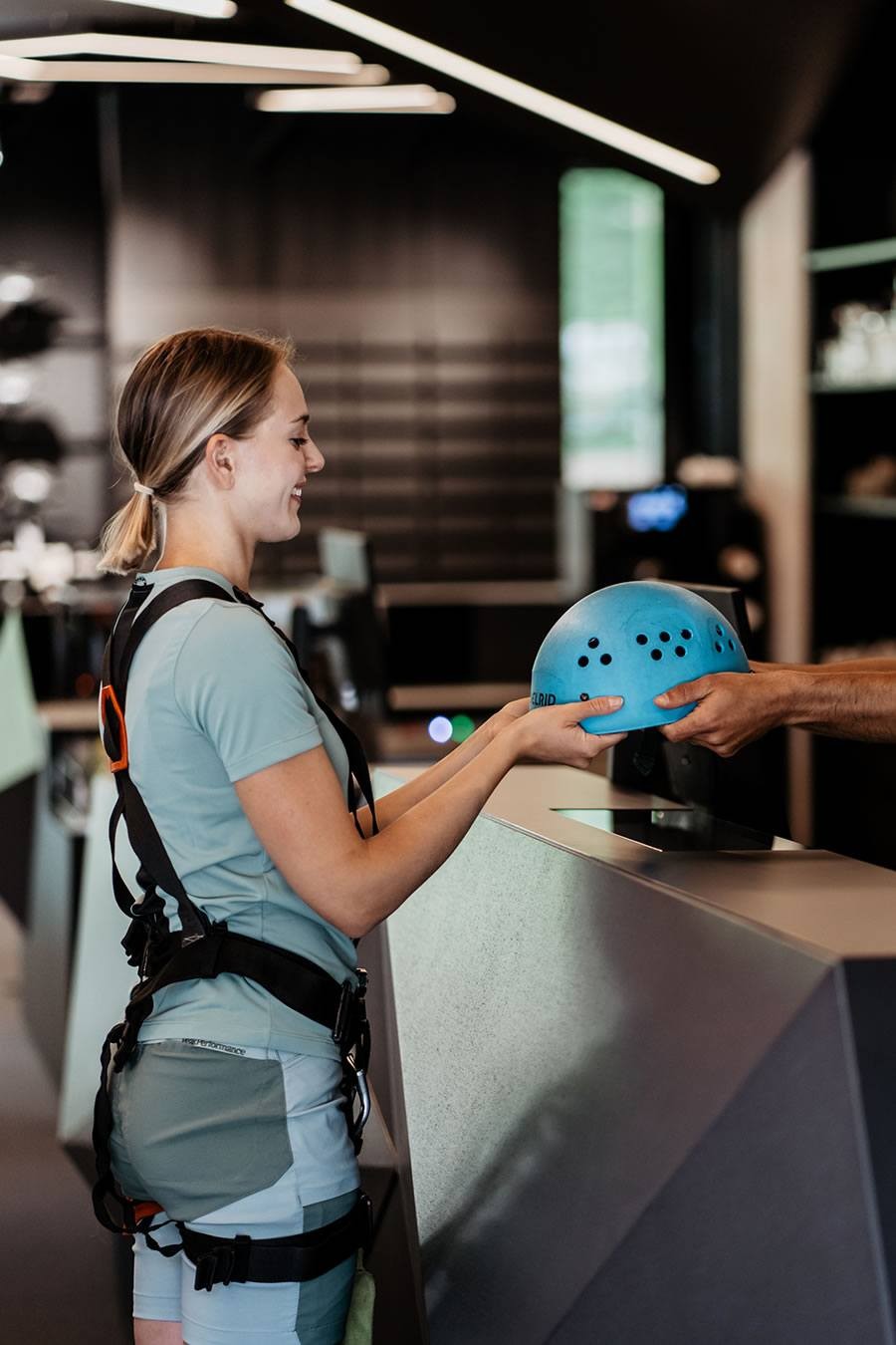Eine Frau erhält einen blauen Helm von einem Mitarbeiter von Schernthaner sports in Kleinarl
