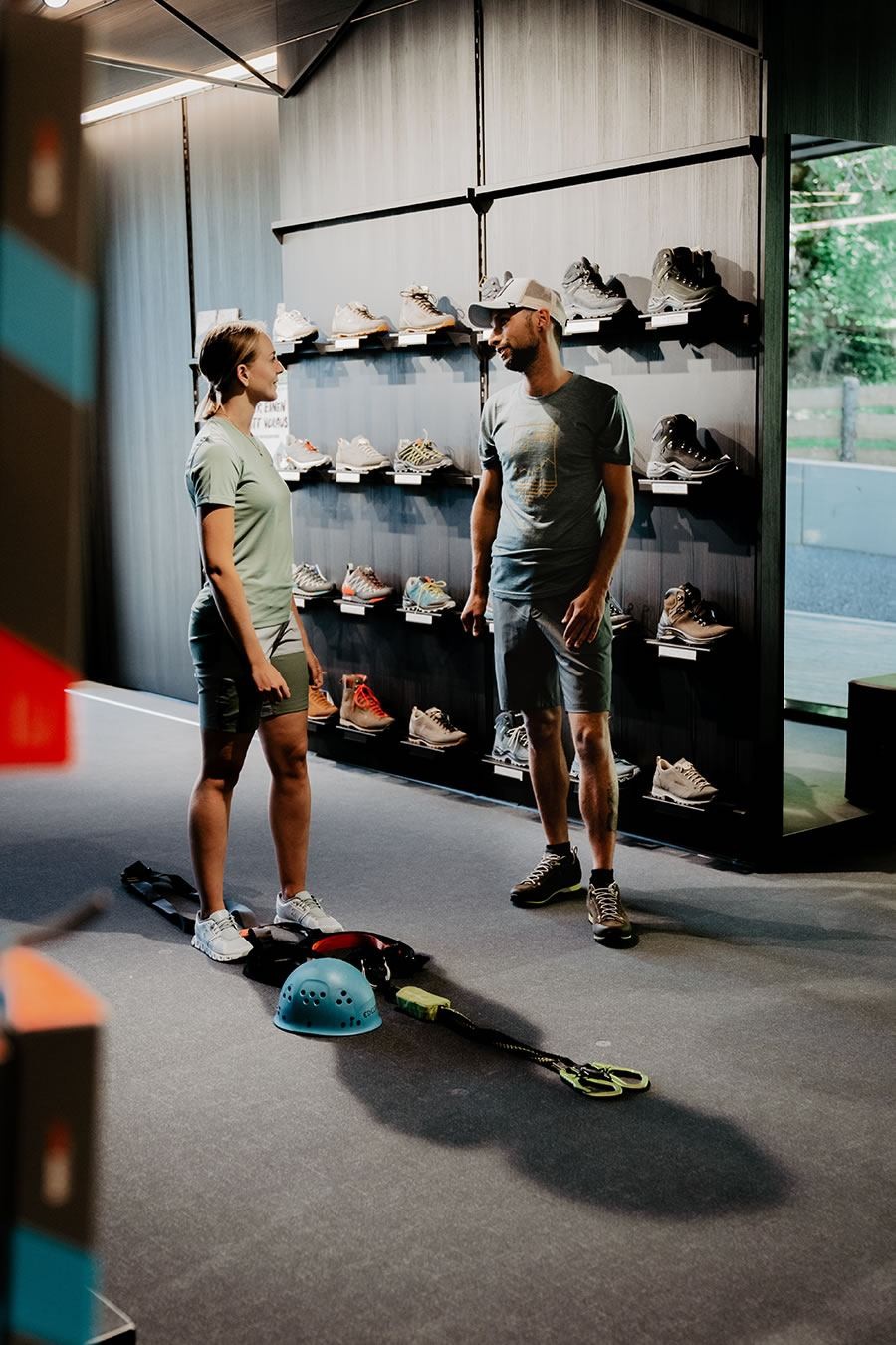 Personen betrachten Schuhe im Schernthaner sports Shop in Kleinarl mit Kletterausrüstung auf dem Boden