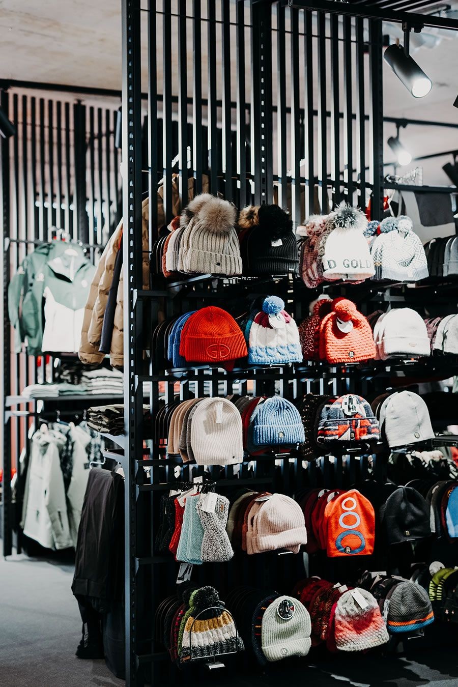 Verschiedene bunte Mützen sind in einem Laden auf Regalen ausgestellt
