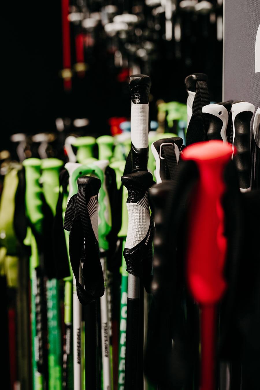 Mehrere bunte Skistöcke stehen dicht nebeneinander