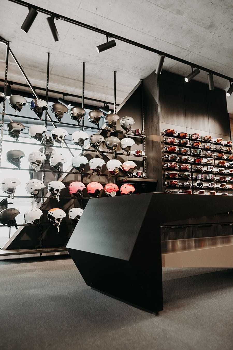 Helme und Brillen sind auf Regalen in einem modernen Geschäft ausgestellt