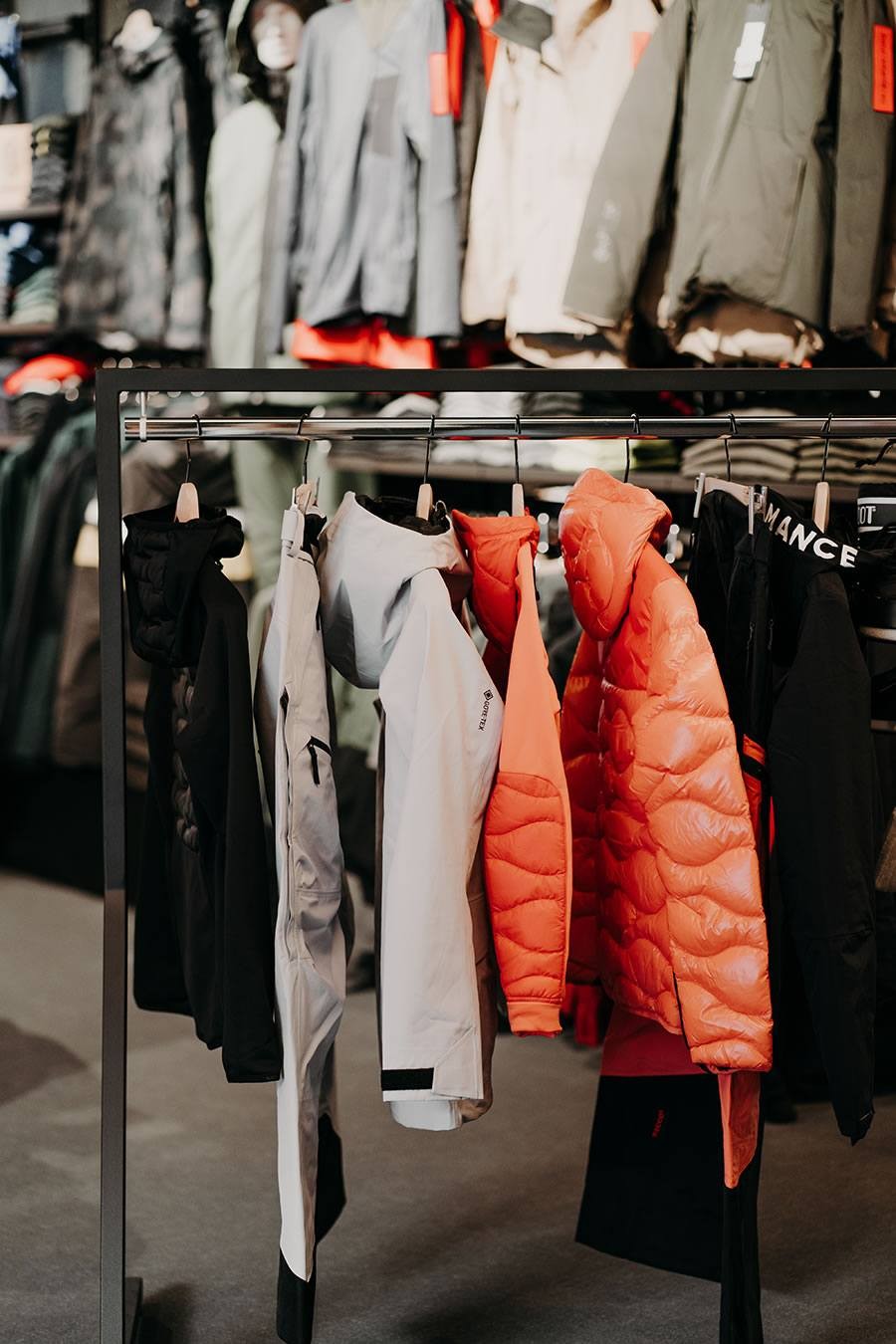 Bunte Jacken hängen an einem Kleiderständer in einem Geschäft