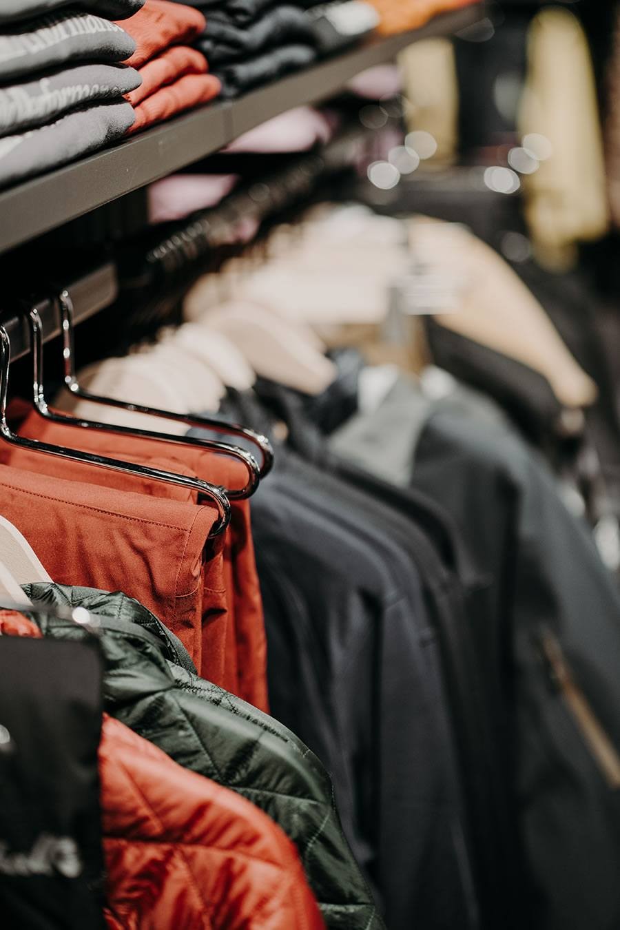 Jacken in verschiedenen Farben hängen im Geschäft