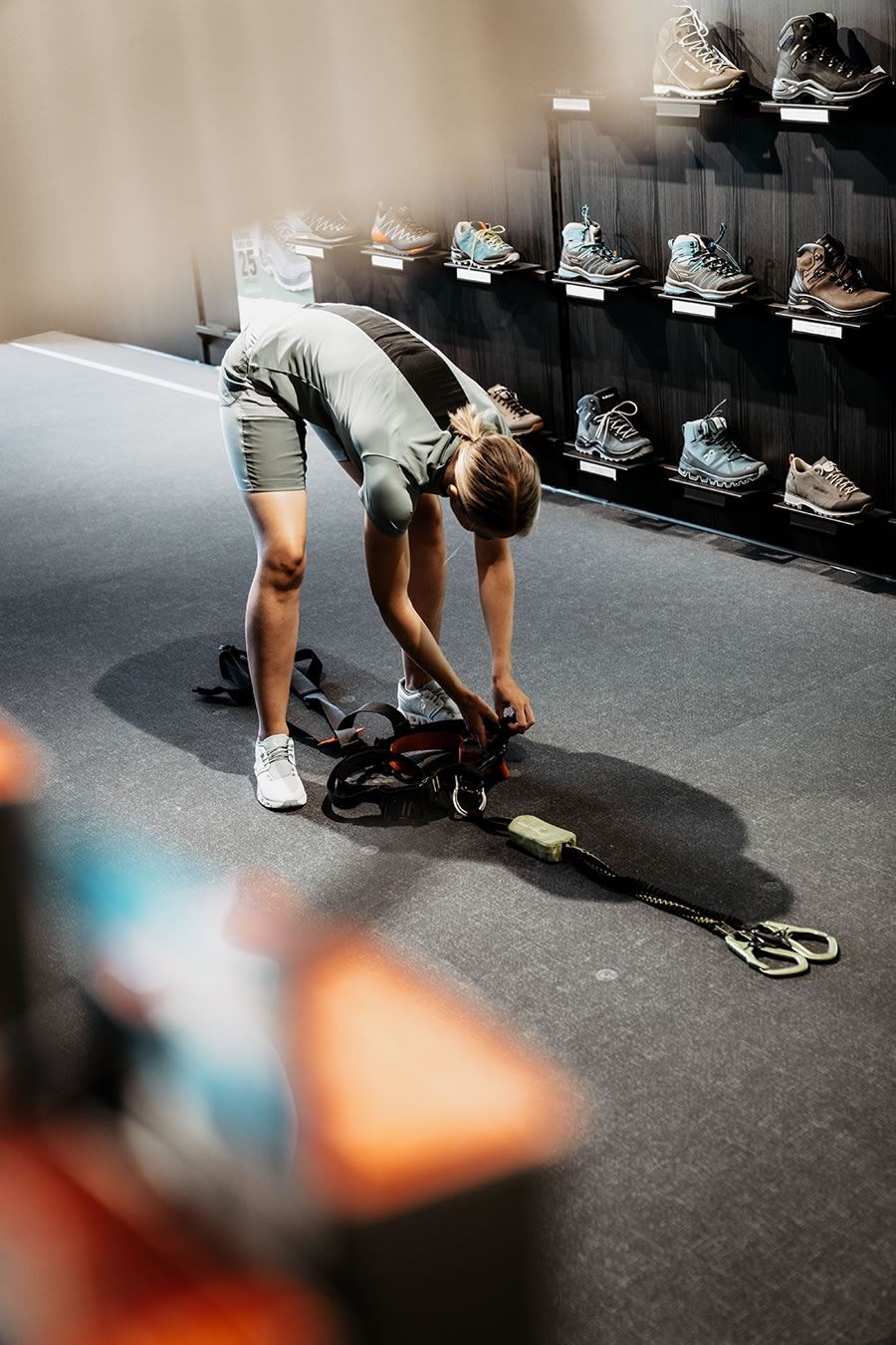 Person beugt sich vor, um Kletterausrüstung bei Schernthaner sports zu ordnen