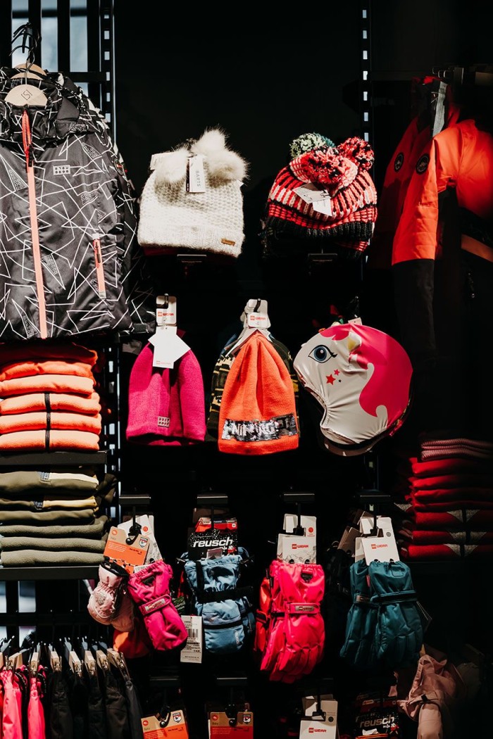 Verschiedene Winteraccessoires wie Mützen und Handschuhe in einem Sportgeschäft ausgestellt