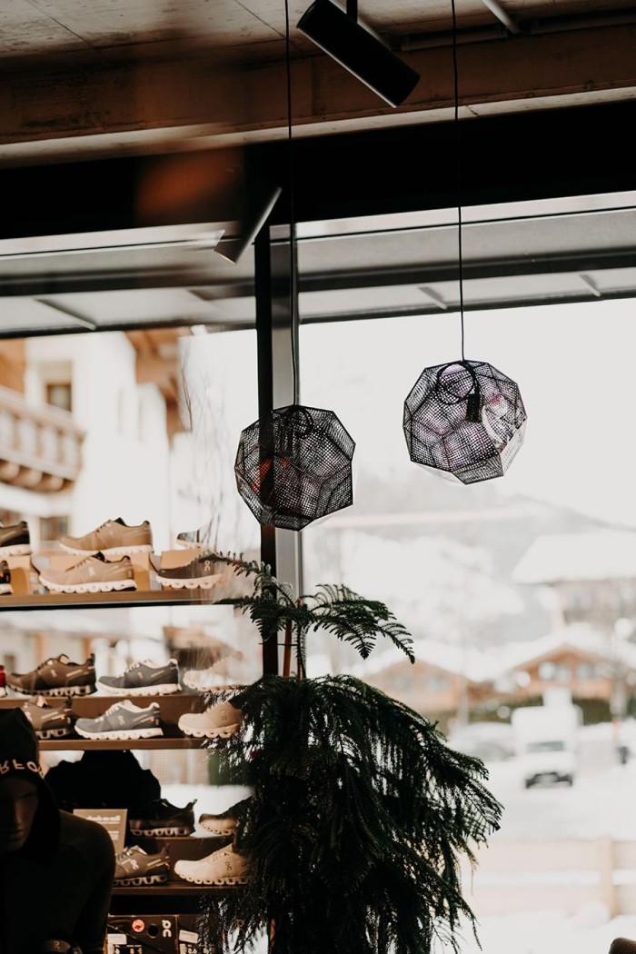 Ein Schuhgeschäft mit hängenden Lampen und Schneelandschaft im Hintergrund