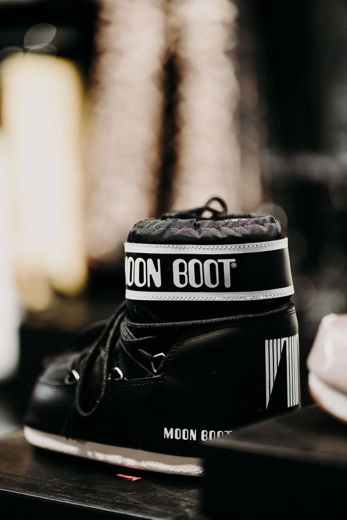 Ein schwarzer Moon Boot steht auf einem unscharfen Hintergrund