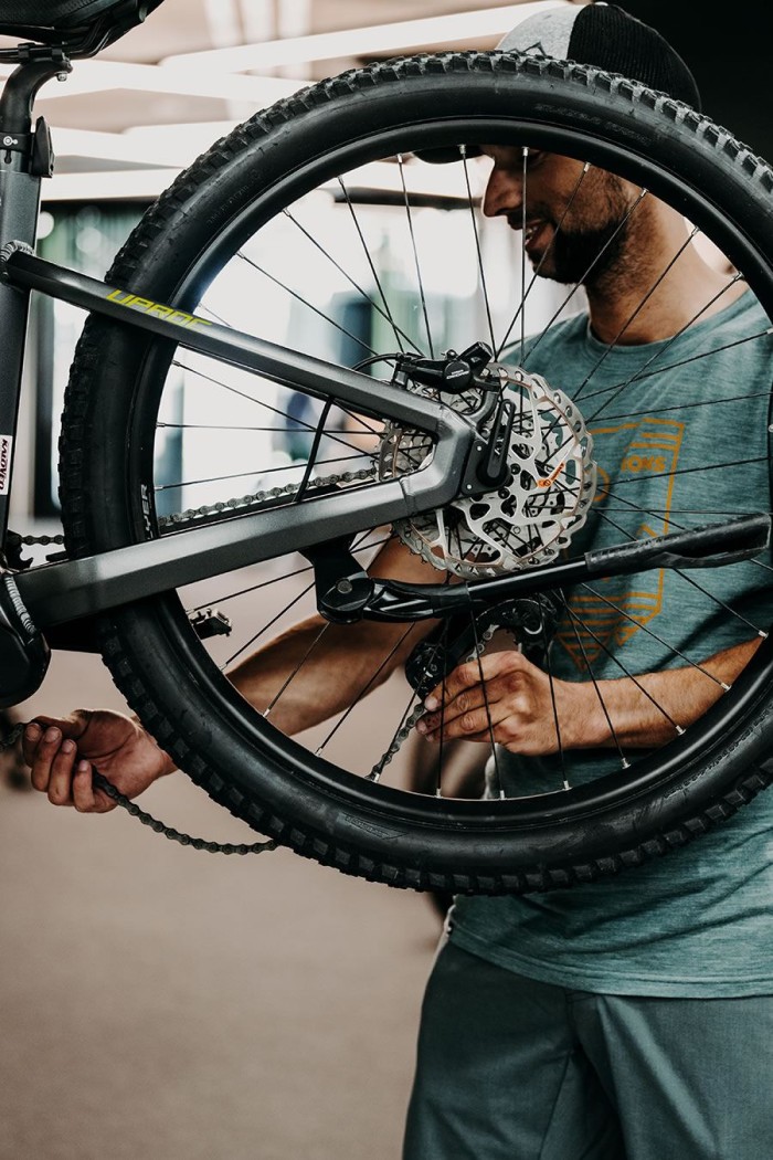 Ein Mann repariert ein Fahrrad, indem er an der Kette arbeitet