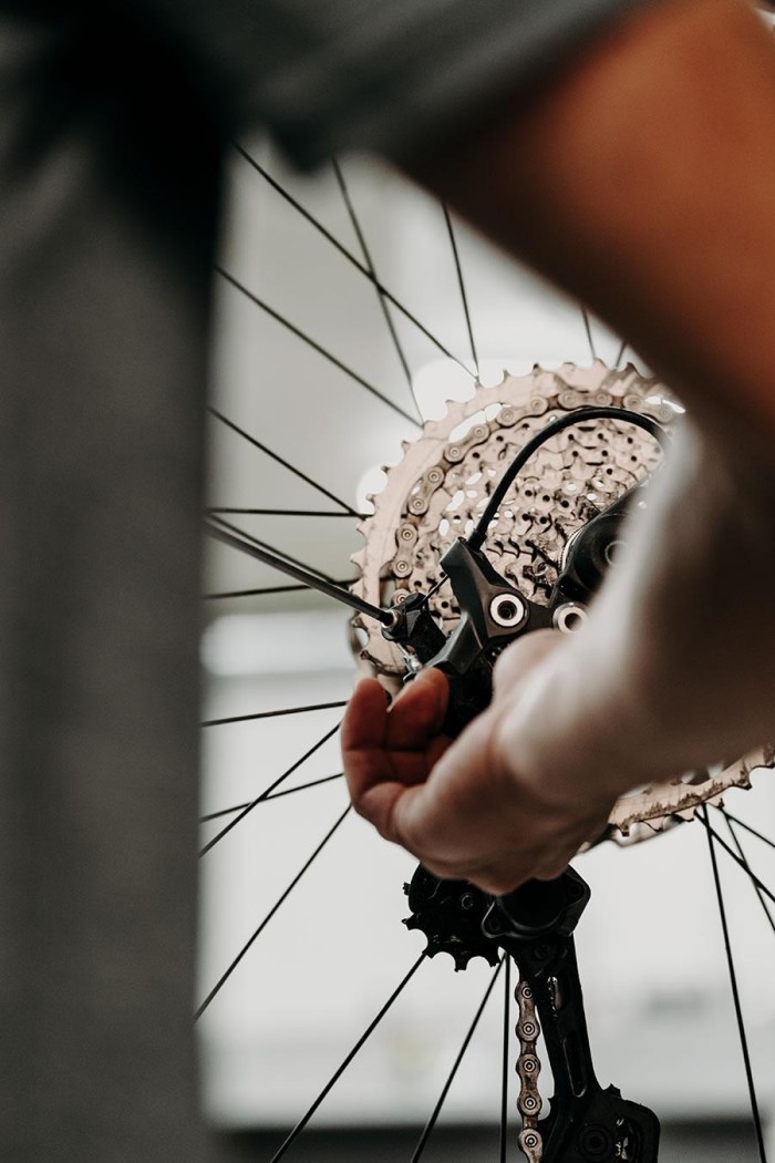 Eine Person justiert das hintere Schaltwerk eines Fahrrads