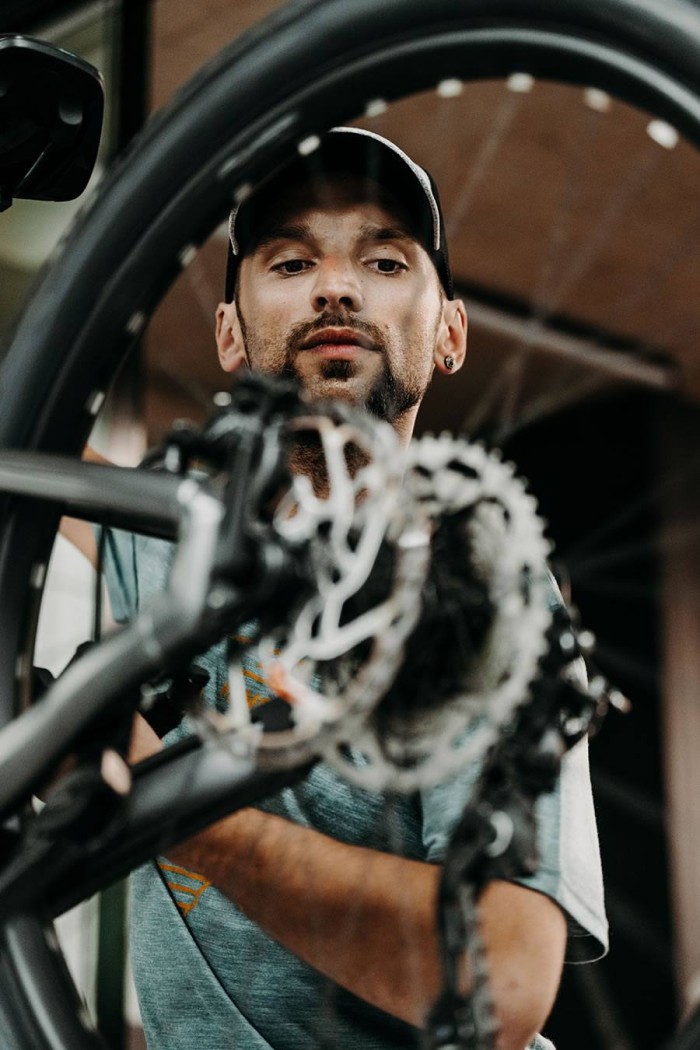 Ein Mann inspiziert sorgfältig das Rad eines Fahrrads