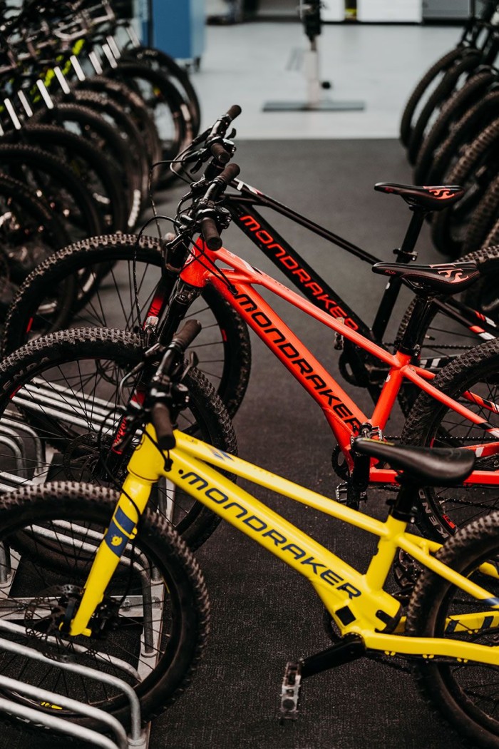 Mehrere Mountainbikes der Marke Mondraker stehen in einem Fahrradständer