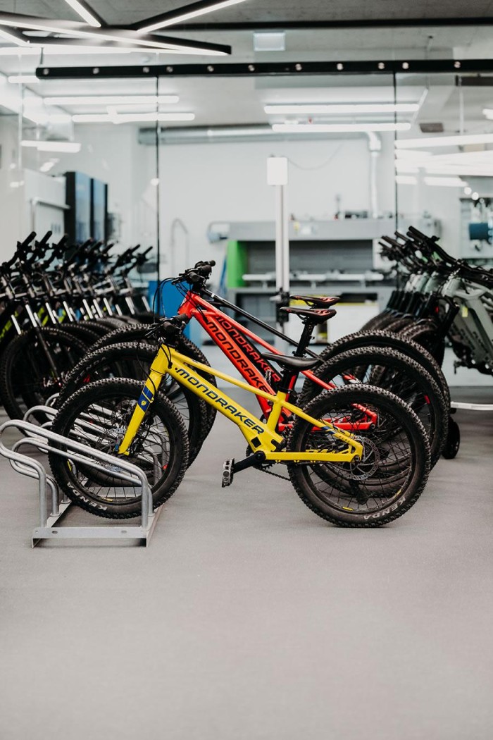 Ein gelbes und ein rotes Fahrrad stehen nebeneinander in einem modernen Laden