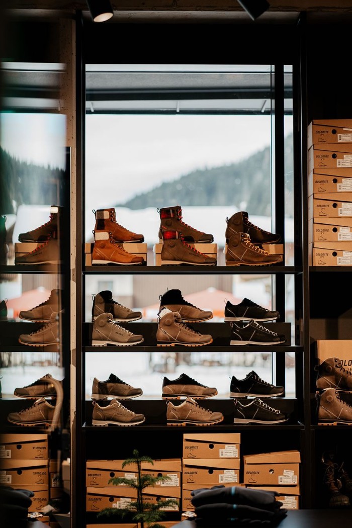 Regal mit verschiedenen Schuhen vor einem Fenster mit Blick auf eine verschneite Landschaft