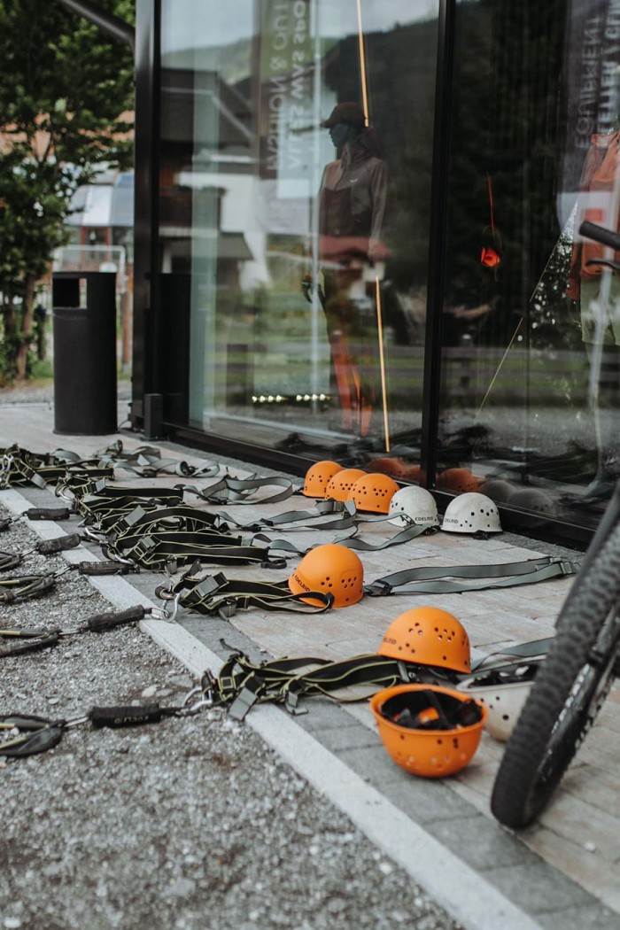Kletterhelme und Gurte liegen neben einem Schaufenster auf dem Boden
