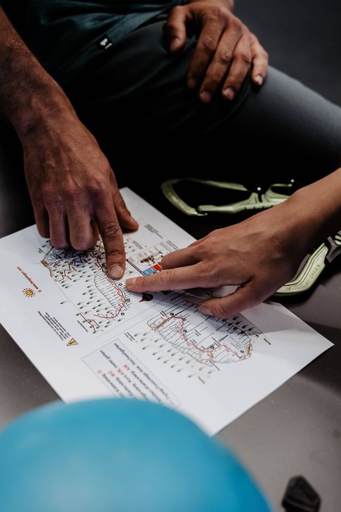 Zwei Personen zeigen auf eine gedruckte Karte auf einem Tisch