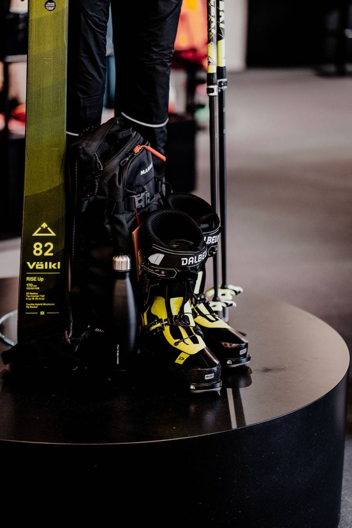 Skiausrüstung mit Rucksack, Stiefeln, Ski und Skistöcken auf einem Tisch ausgestellt