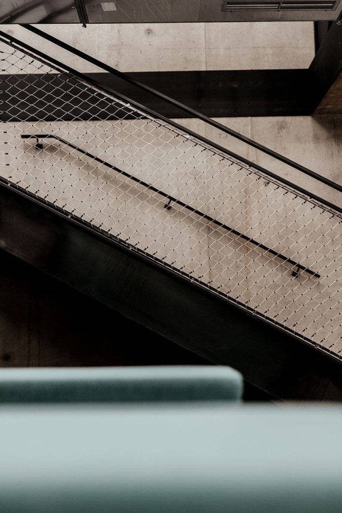 Treppe mit Gittergeländer in einem modernen Innenraum aus Beton