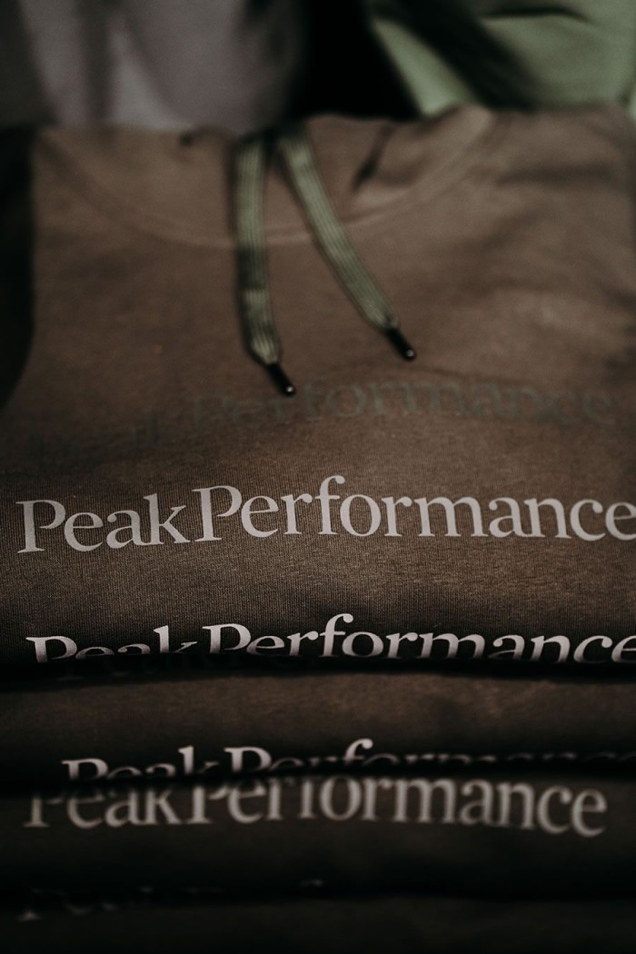 Braune Hoodies mit dem Aufdruck "Peak Performance" in einem Stapel