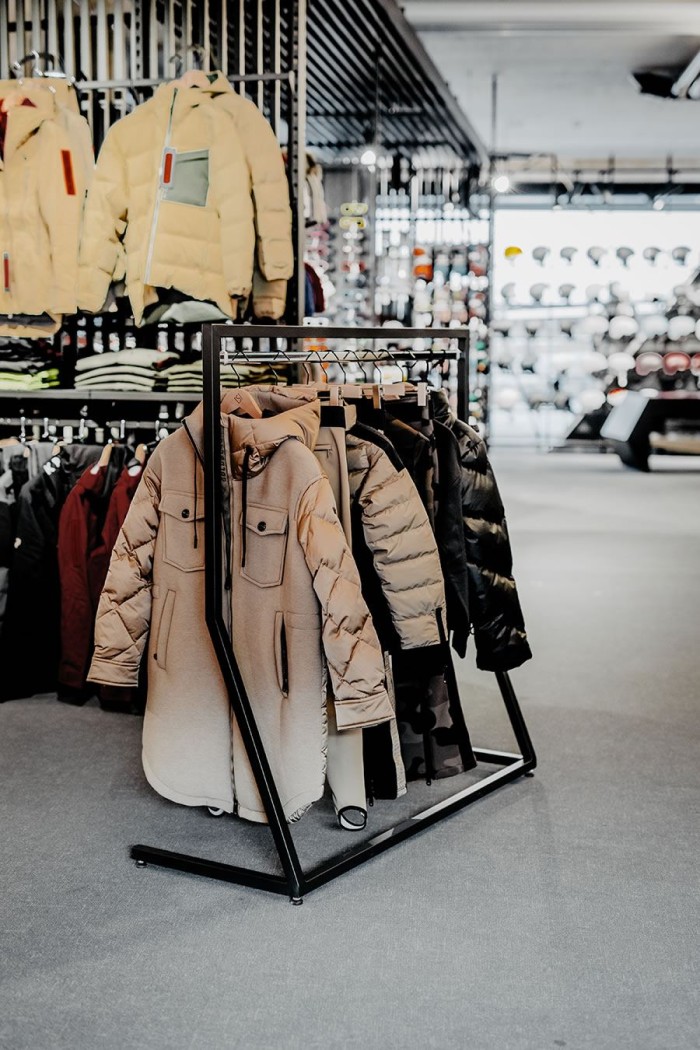 Jacken und Mäntel hängen ordentlich auf einem Kleiderständer in einem Bekleidungsgeschäft