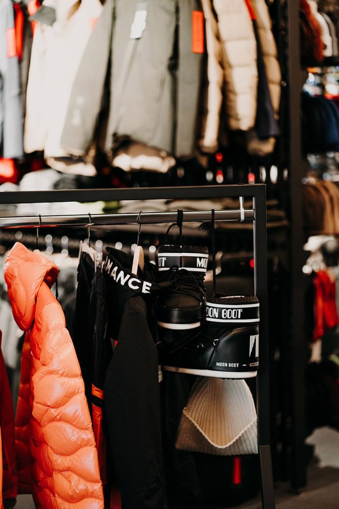 Kleiderständer mit Jacken, Mützen und Stiefeln in einem Geschäft